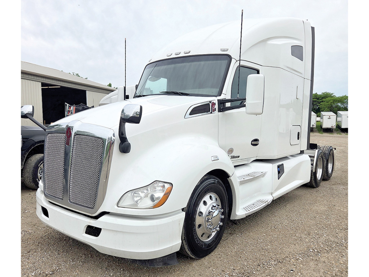 Kenworth T680 tractor-trailer in white showing front grille and cab, side view, no visible text on labels.