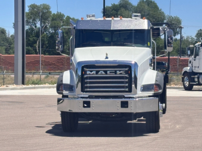 Front view of a white 2026 Mack GR64B roll-off truck with chrome grille and bumper, large side mirrors, and daytime running lights visible.