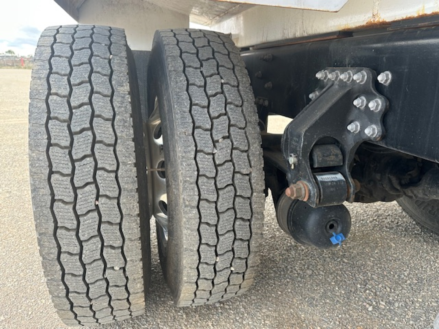 Wheel pair showing dual rear tires on Mack MD7 chassis with suspension and mounting hardware.