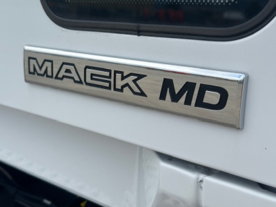 Mack MD badge on white truck exterior showing MA CK MD chrome emblem.