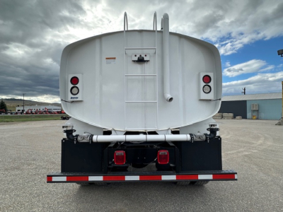 Rear view of a white 2025 Mack MD7 truck/tractor with tanker rear and rear lights, ladder, and reflective rear bumper.