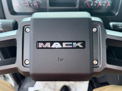 Mack MD7 steering wheel center with MAC K logo and dashboard gauges visible in background.