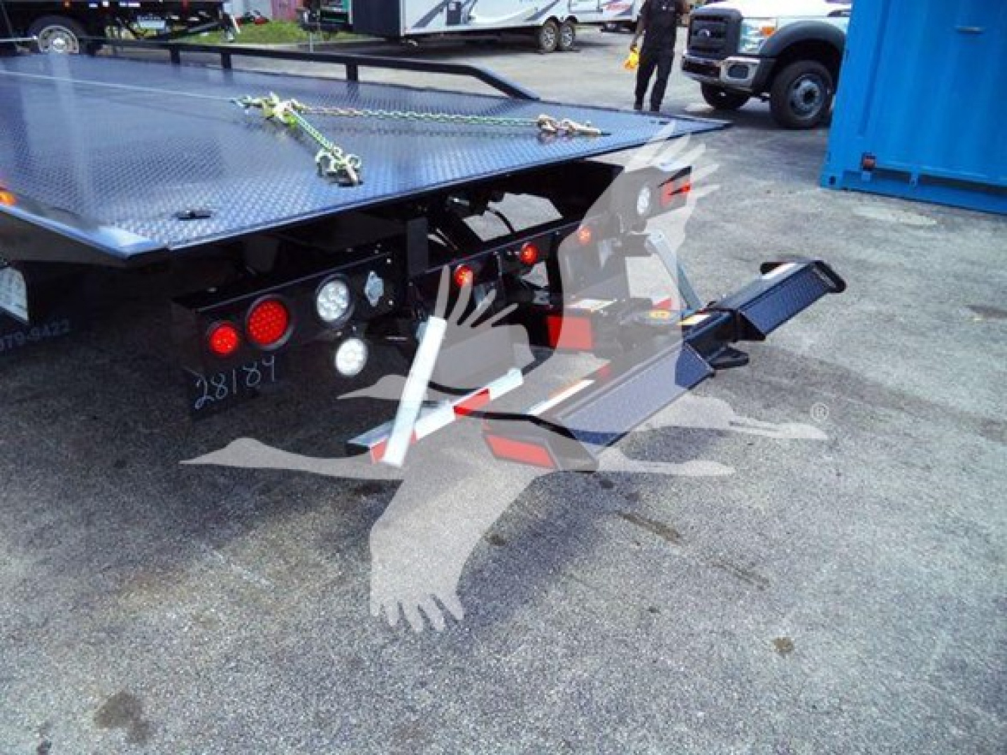 Truck rollback bed rear with platform and hydraulic wheel lift, taillights, and metal work surface; part of a 2023 Chevrolet Silverado 6500HD listing.