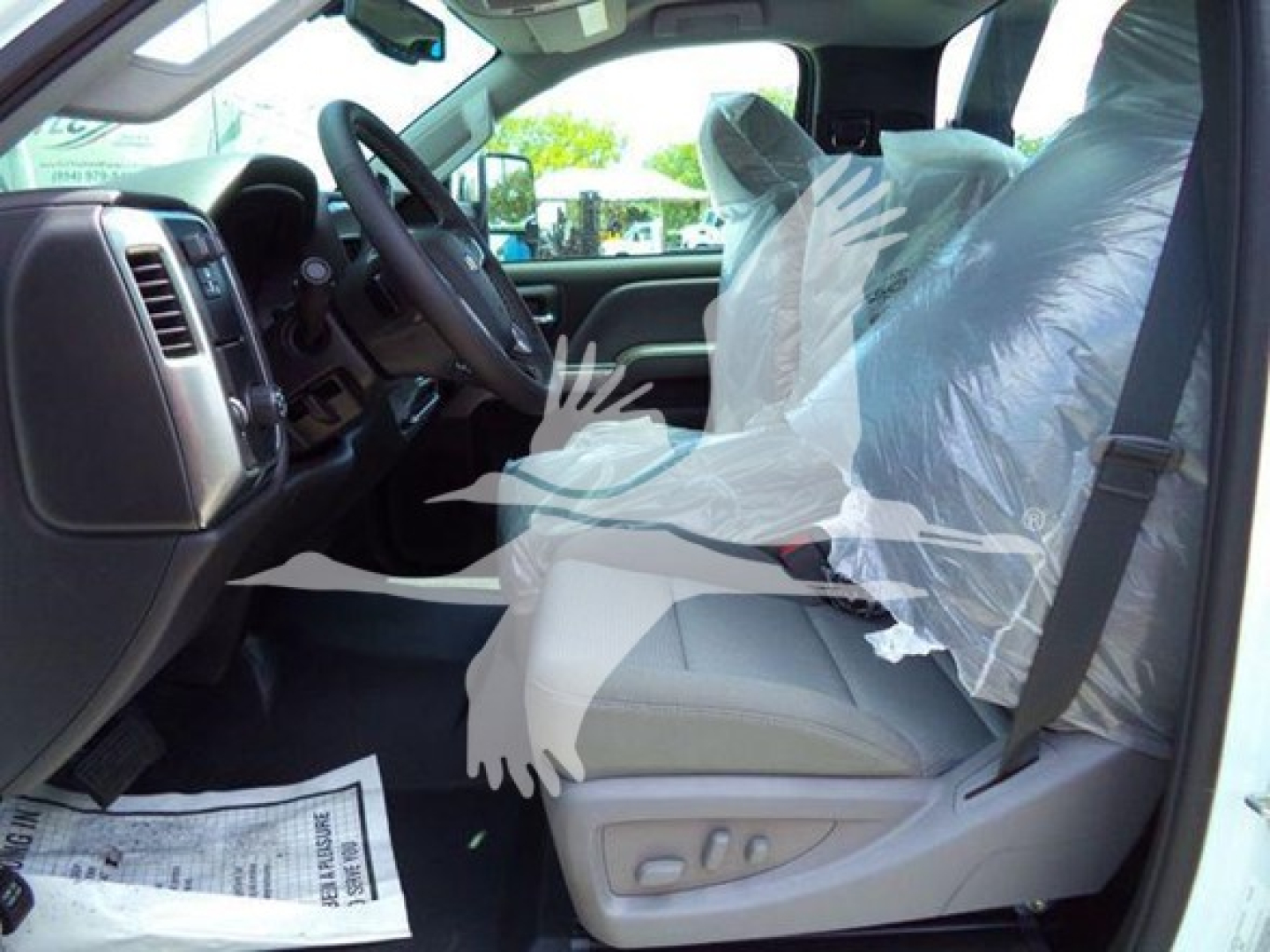 Chevrolet Silverado 6500HD interior driver seat view with plastic seat covers and dashboard