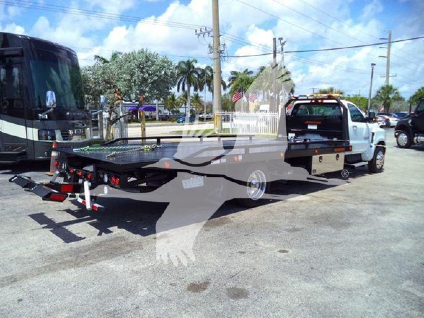 Truck rollback tow truck with flatbed in-service showing rear platform and towing equipment.