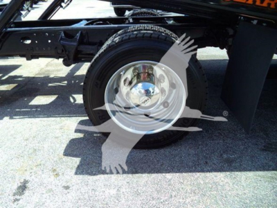 Wheel and suspension area of a 2023 Chevrolet Silverado 6500HD rollback truck showing single rear wheel, chrome hubcap, and chassis components.