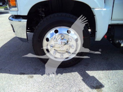 Truck front wheel and chrome hubcap of a white 2023 Chevrolet Silverado 6500HD with wheel and tire visible in side-angle view.