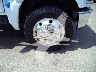 Truck wheel and front fender of a 2023 Chevrolet Silverado 6500HD with chrome hubcap and heavy duty tire.