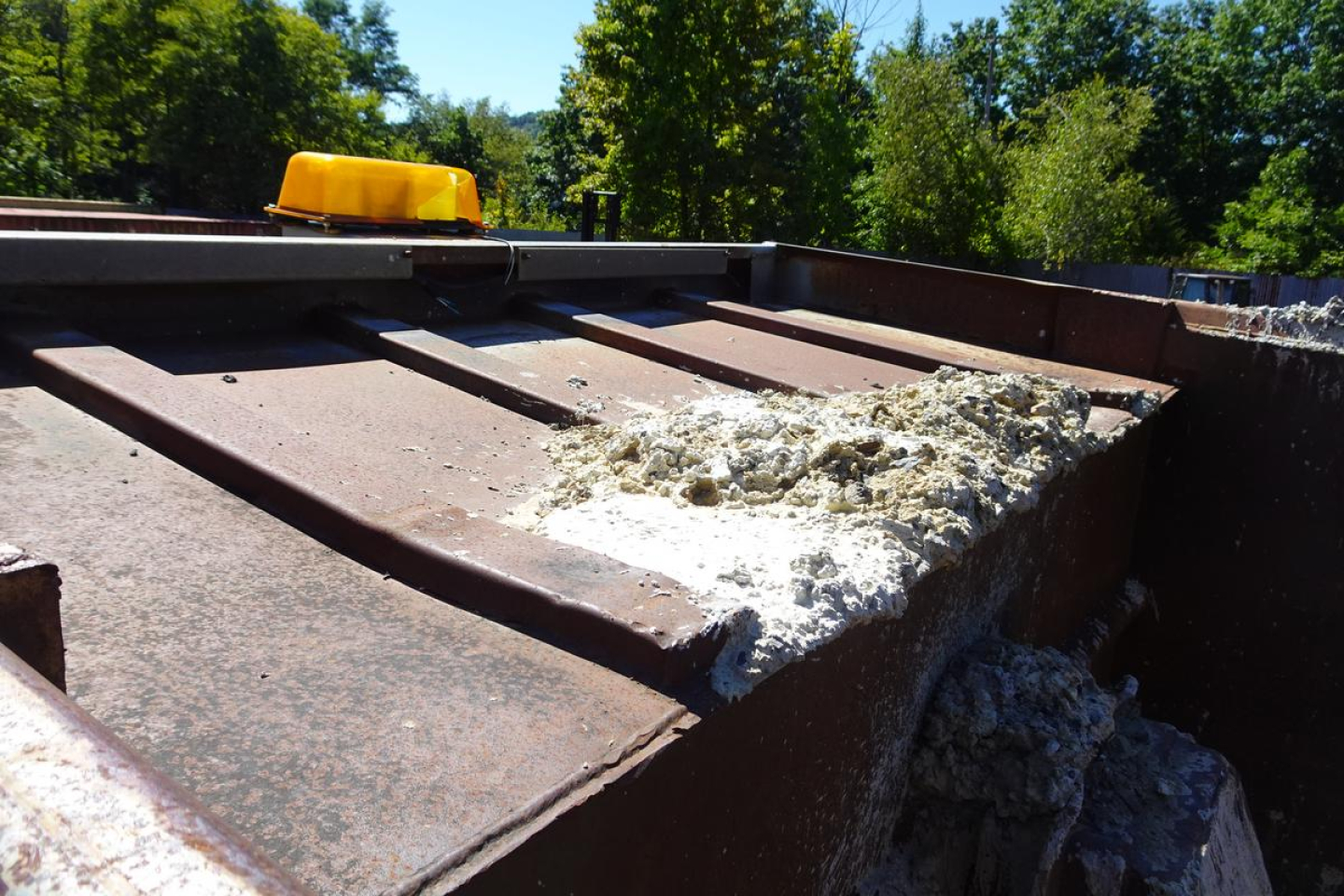Peterbilt 359 dump truck bed showing rusted metal surface and debris.