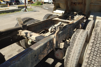 Peterbilt 359 chassis and rear axle showing dual rear wheels and frame with dirty components.