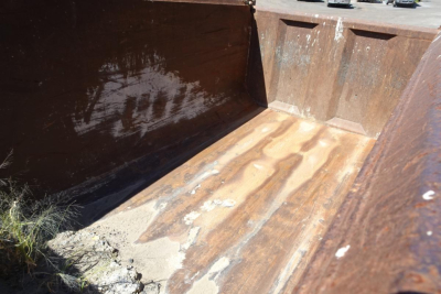 Dump truck bed interior of a 1986 Peterbilt 359 showing rust-stained steel side walls and a worn bed floor.