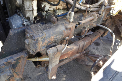 Peterbilt 359 diesel engine bay showing exposed exhaust manifold and drivetrain components in in-service condition.