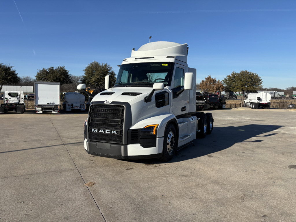 Front three-quarter view of a white 2027 Mack PR64T tractor truck with black grille and hood, showing Mack logo and cab, in a truck lot.