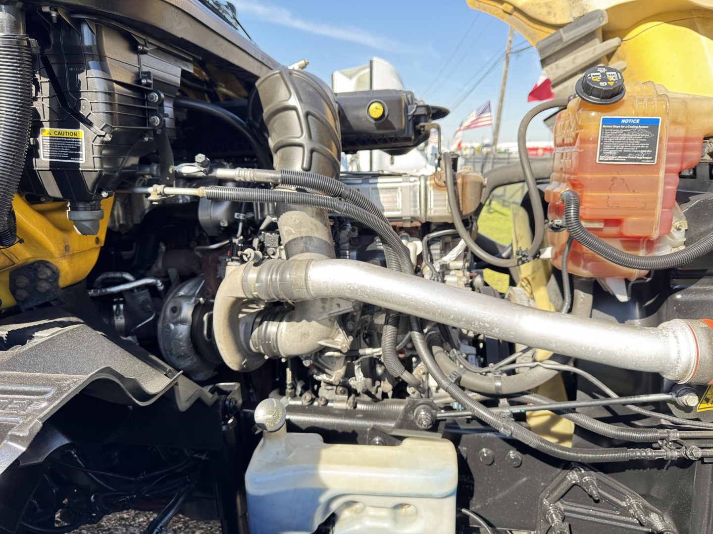 Engine bay of a 2019 International LT truck showing hydraulic lines, coolant reservoir, and various engine components.