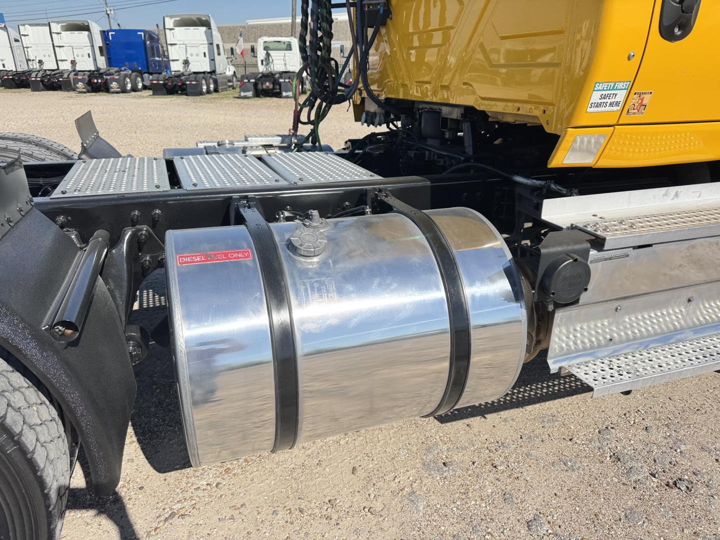 Truck fuel tank and chassis area of a 2019 International LT conventional daycab showing polished aluminum diesel fuel tank and step platform.