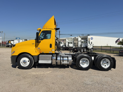 Side view of a yellow 2019 International LT conventional day cab truck showing a long chassis with dual rear axles and chrome fuel tanks.