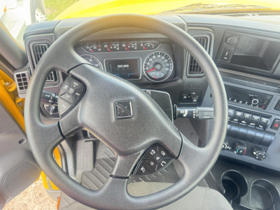 Interior of a 2019 International LT truck cab showing steering wheel with control buttons, dashboard gauges, and center console.