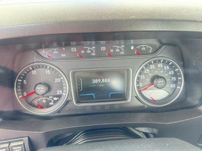 Dashboard interior of a 2019 International LT showing analog gauges, digital odometer reading 389,888 miles, and multiple dials for RPM and speed.