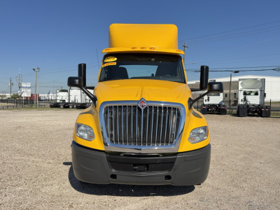 International LT conventional daycab yellow truck front view showing chrome grille and headlights.