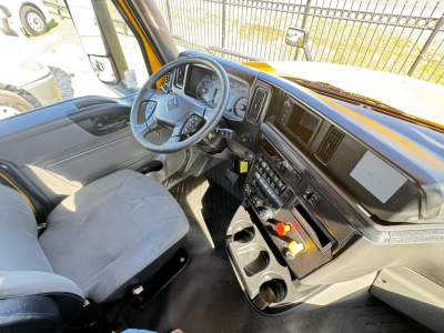 Interior of a 2019 International LT daycab truck cab showing steering wheel, dashboard, touchscreen display, gear controls, and storage compartments.