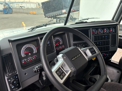 Mack PI64 truck interior cockpit showing steering wheel and instrument cluster with gauges and controls.