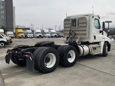 Truck chassis of a 2018 Freightliner Cascadia125 daycab showing rear triple-axle drivetrain and white cab.