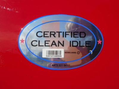 Certification sticker on red truck showing Certified Clean Idle with barcode and Detroit Diesel small text.