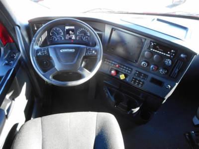 Cab interior of a Freightliner Cascadia 126 truck showing steering wheel, dashboard with gauges, center console, and touchscreen display.