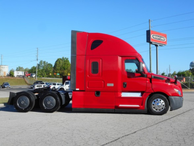 Freightliner Cascadia 126 tractor- red cab in side view with sleeper, long wheelbase, no trailer attached.