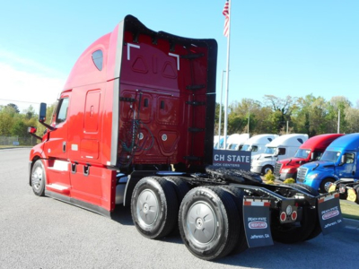 Cab view of a red Freightliner Cascadia 126 truck with sleeper, rear wheels visible, showing fifth wheel and chassis.