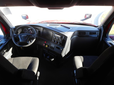 Cab interior of a Freightliner Cascadia truck showing steering wheel, dashboard with multiple gauges, center console, and seats.