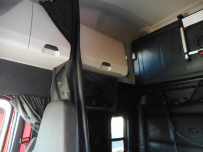 Cab interior showing sleeper area and overhead storage in a Freightliner Cascadia truck