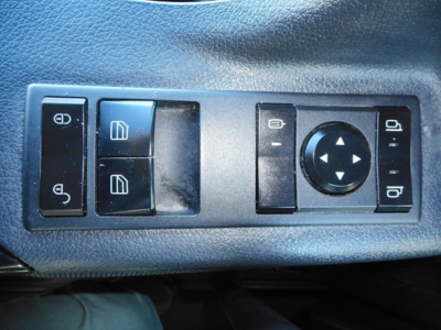 Truck interior panel showing window/lock controls and circular joystick-like knob on door armrest.