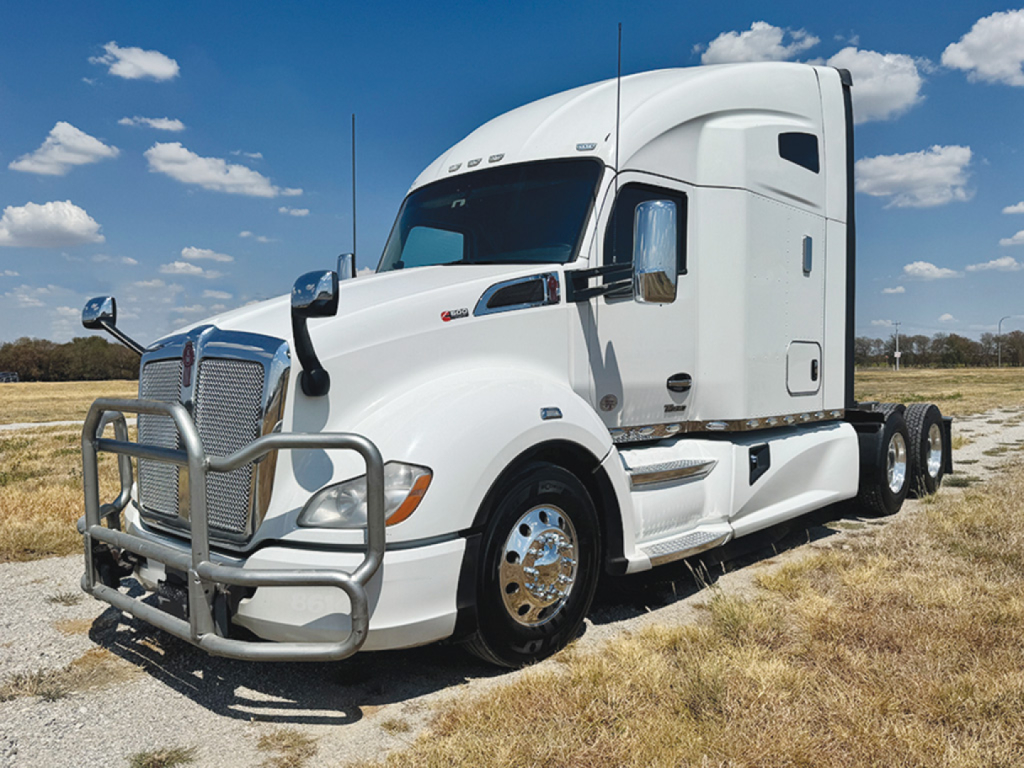 Kenworth T680 highway tractor cab side view showing chrome bumper grill guard and aerodynamic fenders.