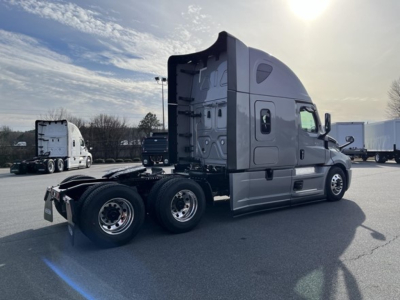 Freightliner Cascadia 126 tractor-trailer side view showing sleeper cab, dual rear axles, and chrome wheels.