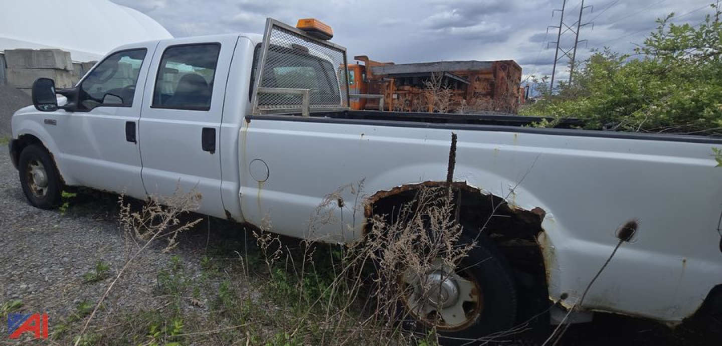 Ford F-350 XL Super Duty crew cab pickup truck side view with long bed, showing rear wheel well and body damage.