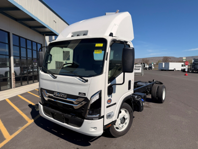 Isuzu NPRXD cab and chassis truck in white, side view with raised cab, front grille showing Isuzu emblem, headlights, and a clear sky.