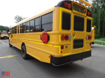 Yellow IC Corporation CE Series school bus rear/side view showing taillights and back doors.