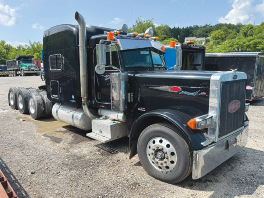 Peterbilt 379 UltraCab Extended Hood tractor truck side view showing black exterior, chrome grille, dual exhaust stacks, and multiple axles.