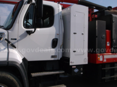 Truck cab and side equipment of a Freightliner 114SD with utility box and crane apparatus visible