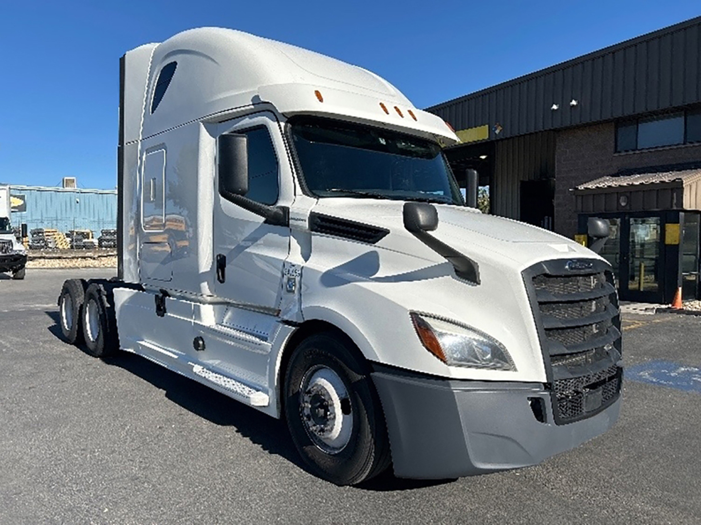 Freightliner Cascadia126 sleeper cab truck side view showing aerodynamic hood and grille with black bumper.