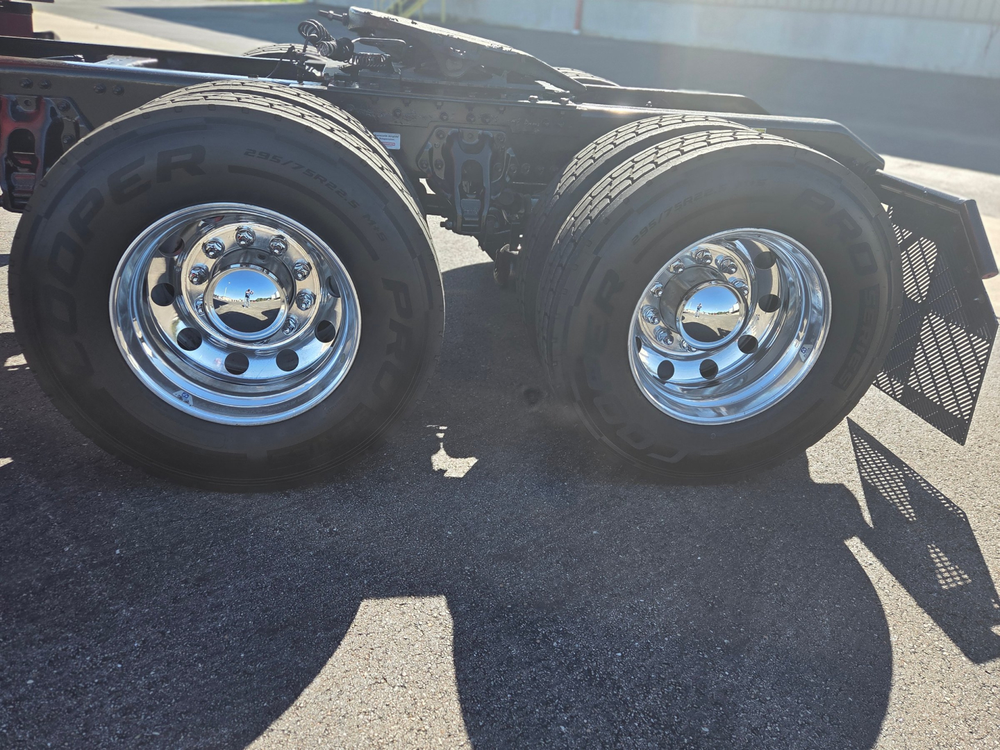 Kenworth T680 wheel chassis showing dual rear dual tires with chrome rims and fender guards.
