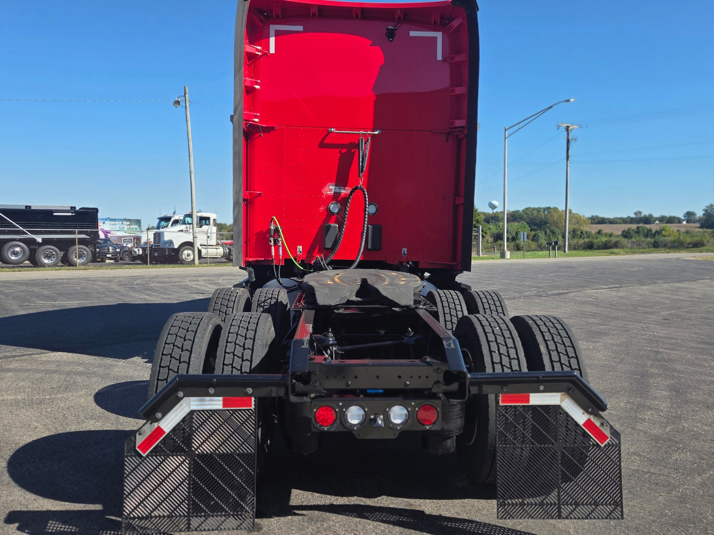 Rear view of a red Kenworth T680 tractor showing dual rear wheels, chassis, and mudflaps.