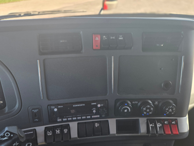 Kenworth T680 interior dashboard view showing center stack with hazard light button, climate controls, and radio unit.