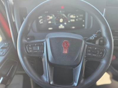 Kenworth T680 steering wheel with center logo and instrument cluster in background; view inside cab showing steering wheel controls