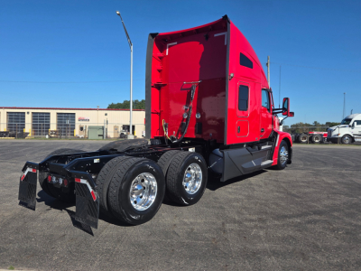 Kenworth T680 sleeper cab truck rear/side view showing dual rear axles and red paint with chrome wheels.