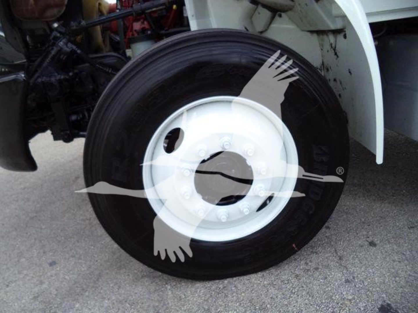 Front wheel of a 2019 International 4300 truck with white hub and black tire; partial chassis components visible.