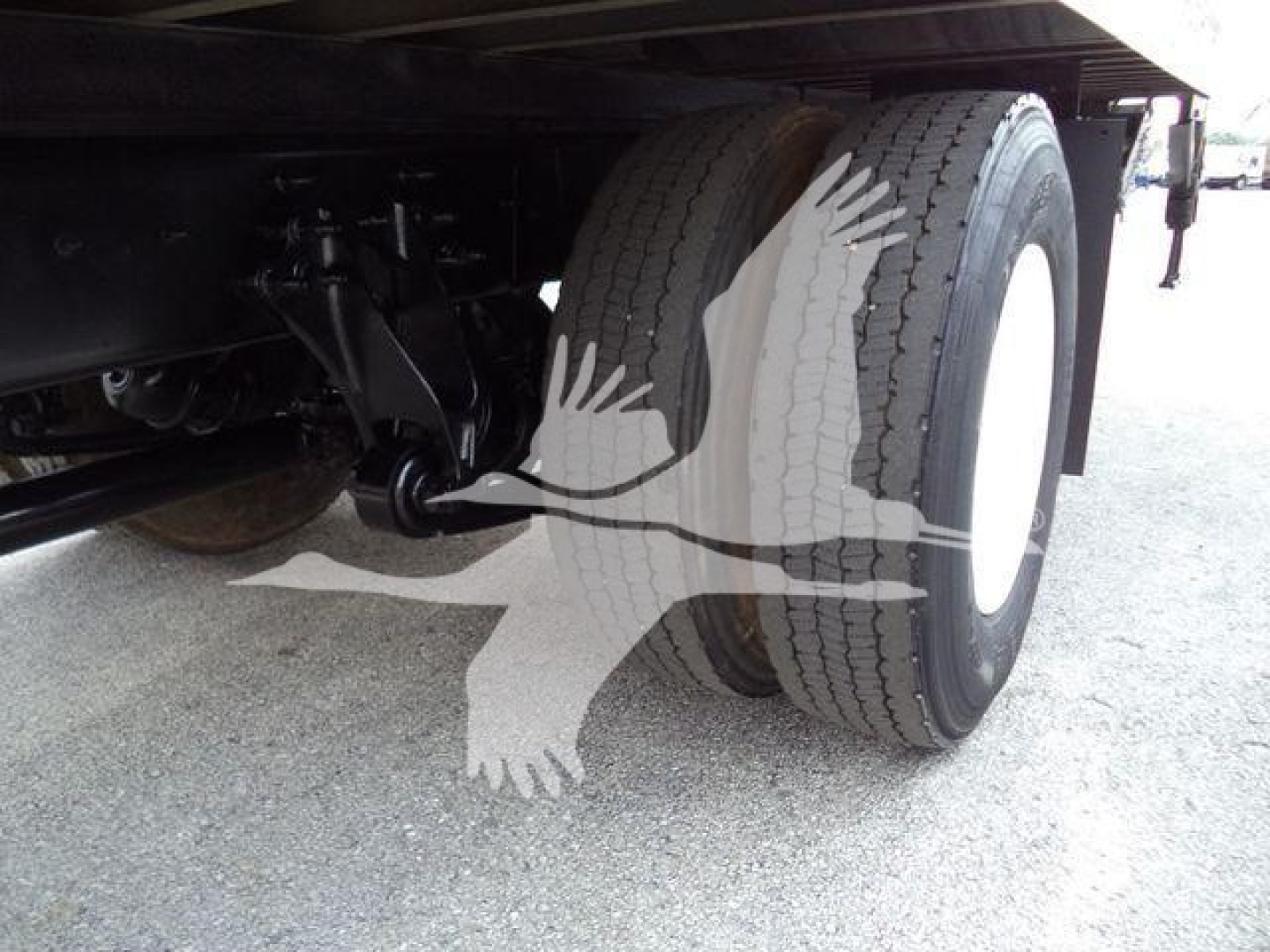 Wheel and suspension of a 2019 International 4300 box truck showing dual rear tires and undercarriage components.