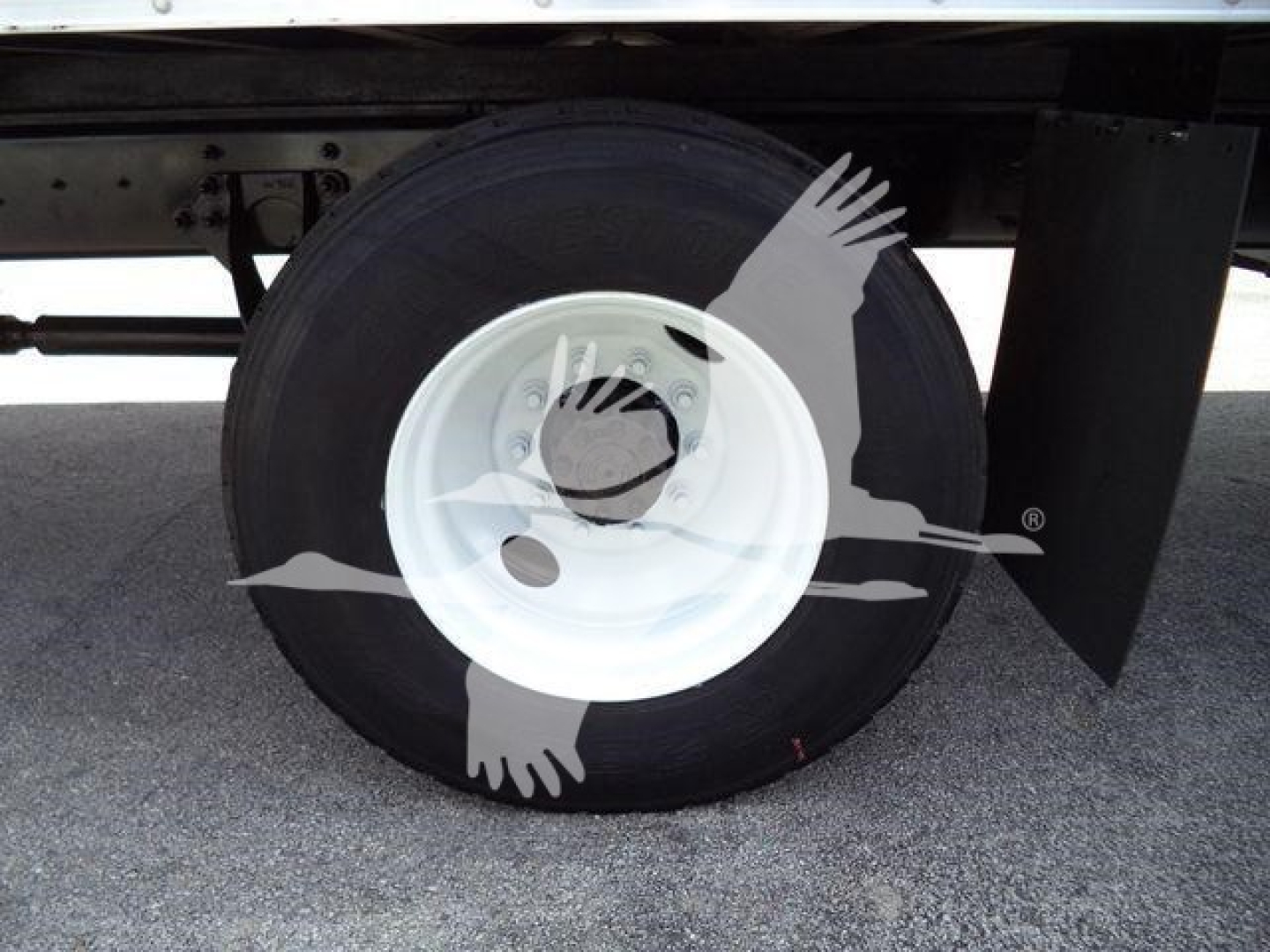 Wheel end view of a 2019 International 4300 box truck showing a white steel rim and black tire with mudflap.