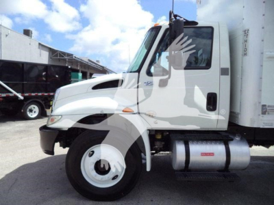 International 4300 box truck side view showing cab with large fuel tank and wheel, white exterior with Black bumper and hood details.